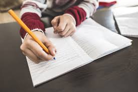 notebook open with student writing in pencil